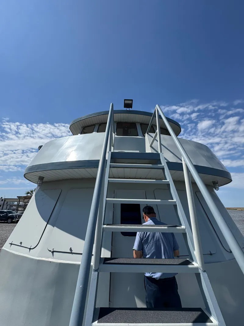 Slide: The Image of 1985 Custom House Boat with stairs, under a clear blue sky. - 42