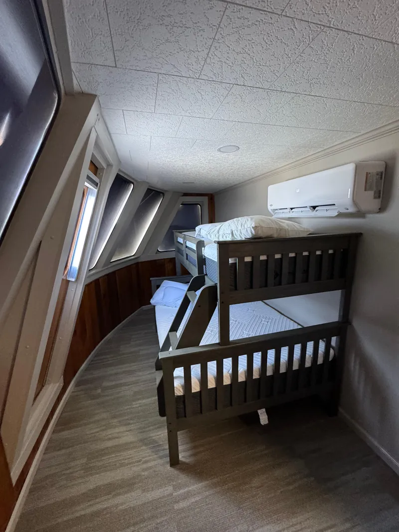 Slide: The Image of Bunk beds in a 1985 custom houseboat interior with angled windows and air conditioning unit. - 44