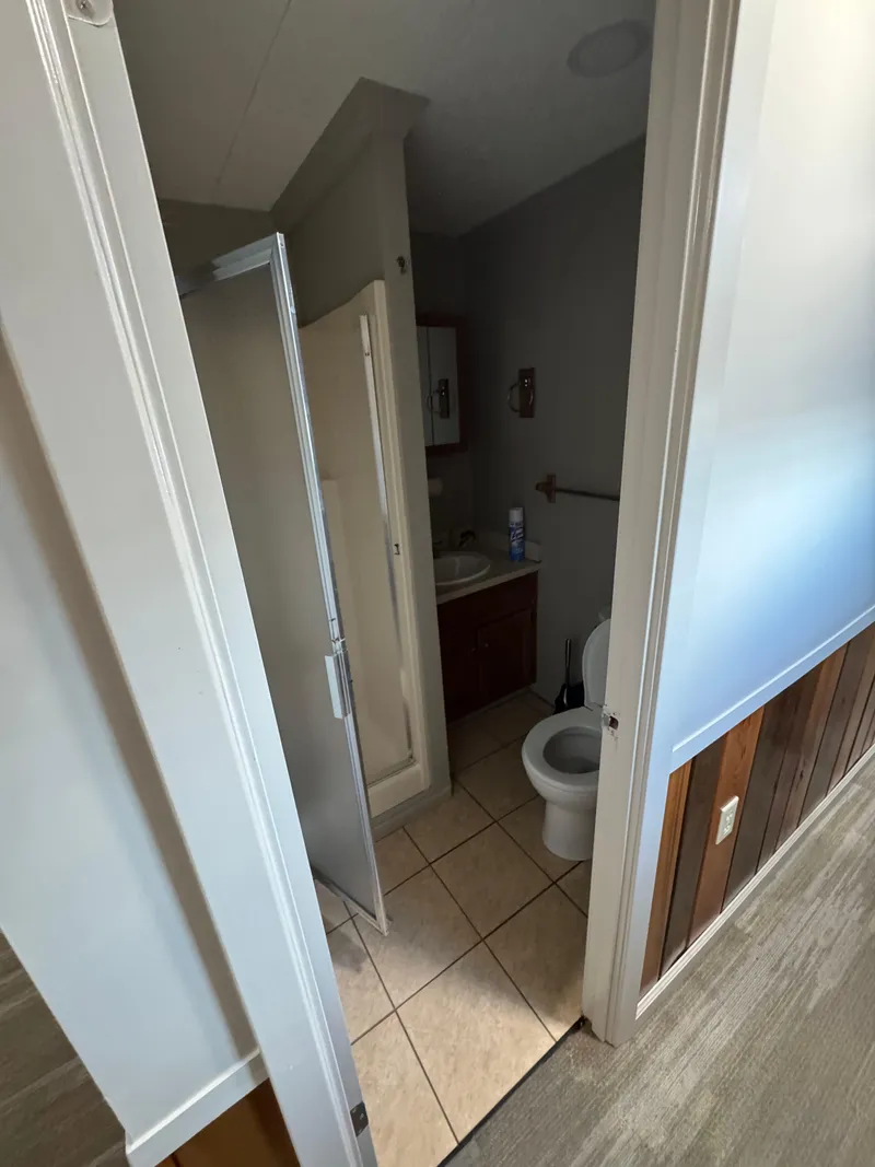 Slide: The Image of Compact bathroom in a 1985 custom houseboat, featuring a shower, toilet, and sink. - 46