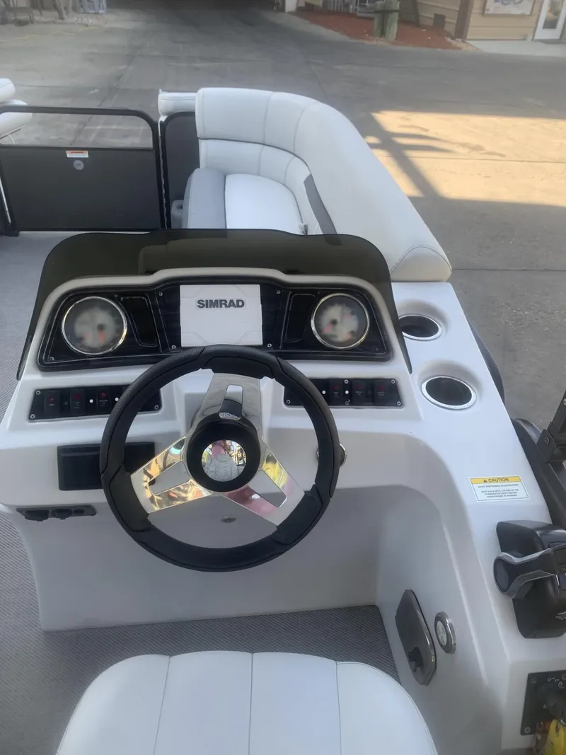 Slide: The Image of 2021 Godfrey Sweetwater 2086 BF boat interior with steering wheel and seating. - 7