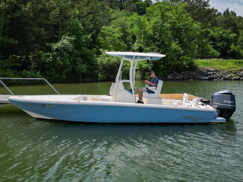 Slide: The Image of 2021 Pathfinder 2500 Hybrid boat docked on a serene lake with Yamaha engine. - 2