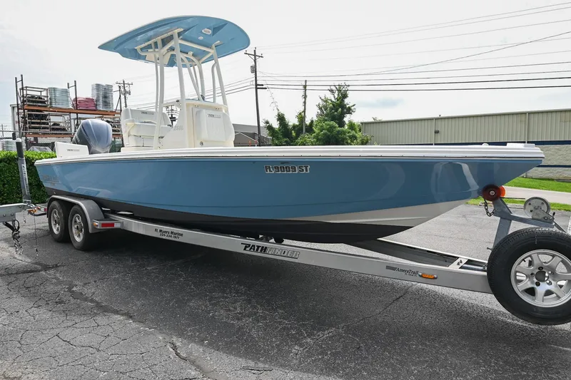 Slide: The Image of 2021 Pathfinder 2500 Hybrid boat on trailer, blue hull, parked outside a building. - 4