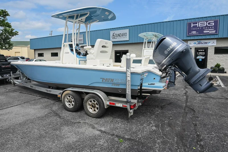 Slide: The Image of 2021 Pathfinder 2500 Hybrid boat in parking lot, showcasing helm and T-top. - 6