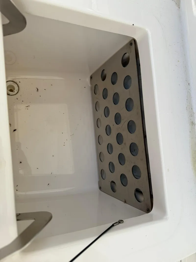 Slide: The Image of 2018 Pursuit DC 365 Dual Console storage compartment with perforated metal shelf. - 11