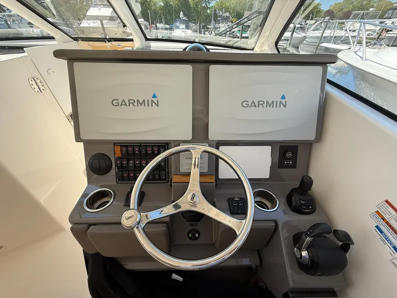 Slide: The Image of 2018 Pursuit DC 365 Dual Console boat helm with Garmin displays and steering wheel. - 15