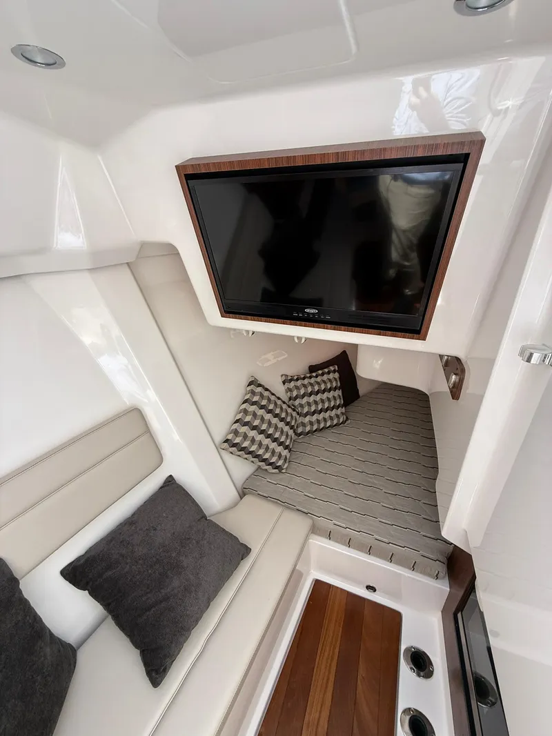 Slide: The Image of 2018 Pursuit DC 365 Dual Console interior with TV, cushions, and seating area. - 18