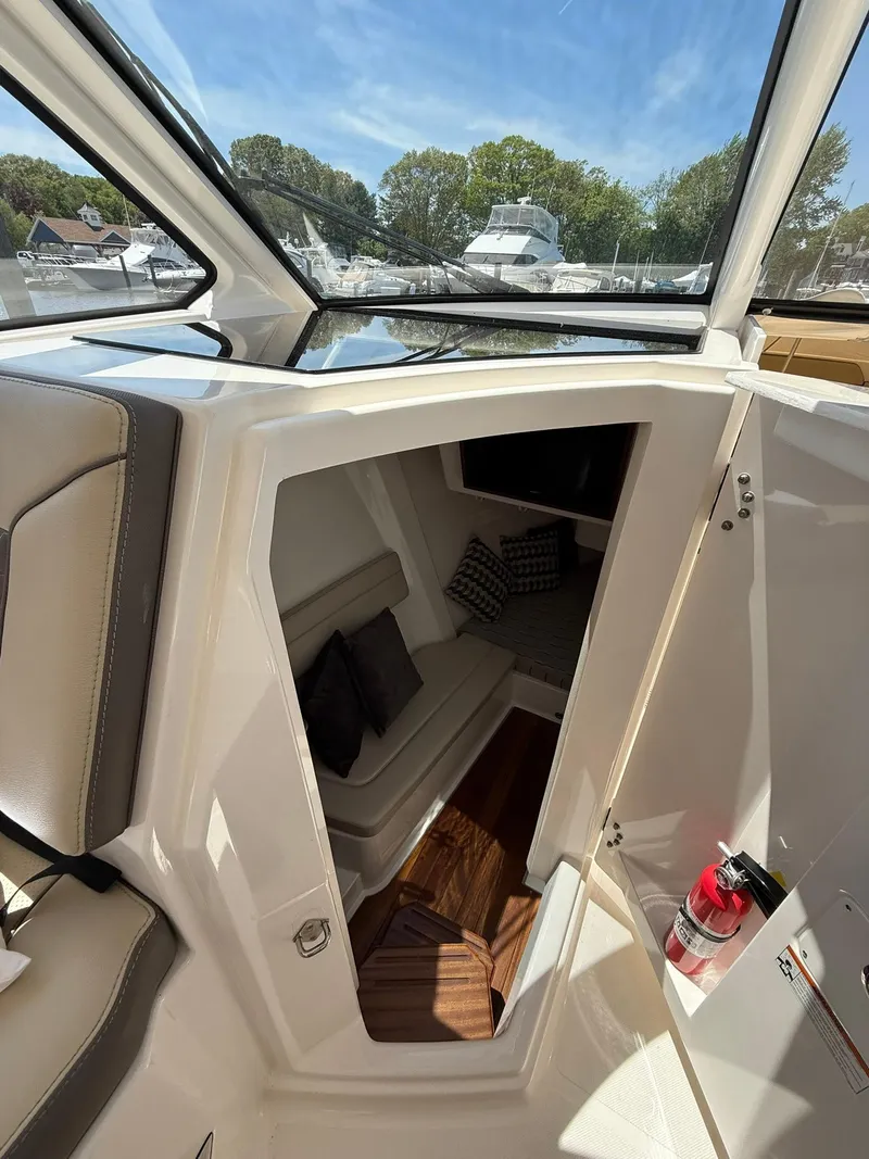 Slide: The Image of 2018 Pursuit DC 365 Dual Console interior cabin with seating and cushions. - 20