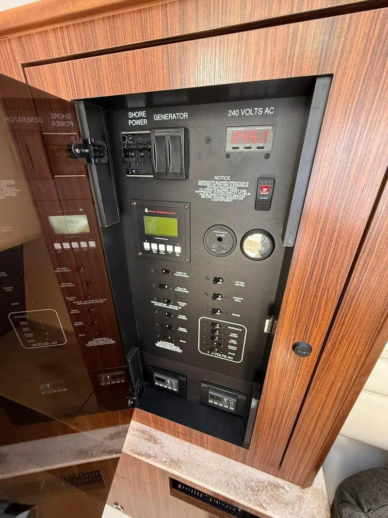 Slide: The Image of Electrical control panel on 2018 Pursuit DC 365 Dual Console boat, featuring various switches and displays. - 22