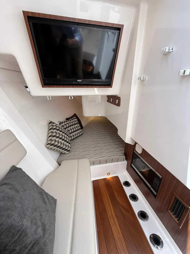 Slide: The Image of Interior of 2018 Pursuit DC 365 Dual Console with TV, seating, and wood accents. - 23