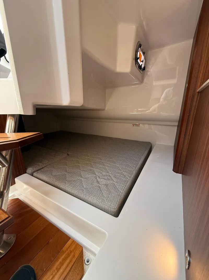 Slide: The Image of 2018 Pursuit DC 365 Dual Console cabin interior with cushioned berth. - 26