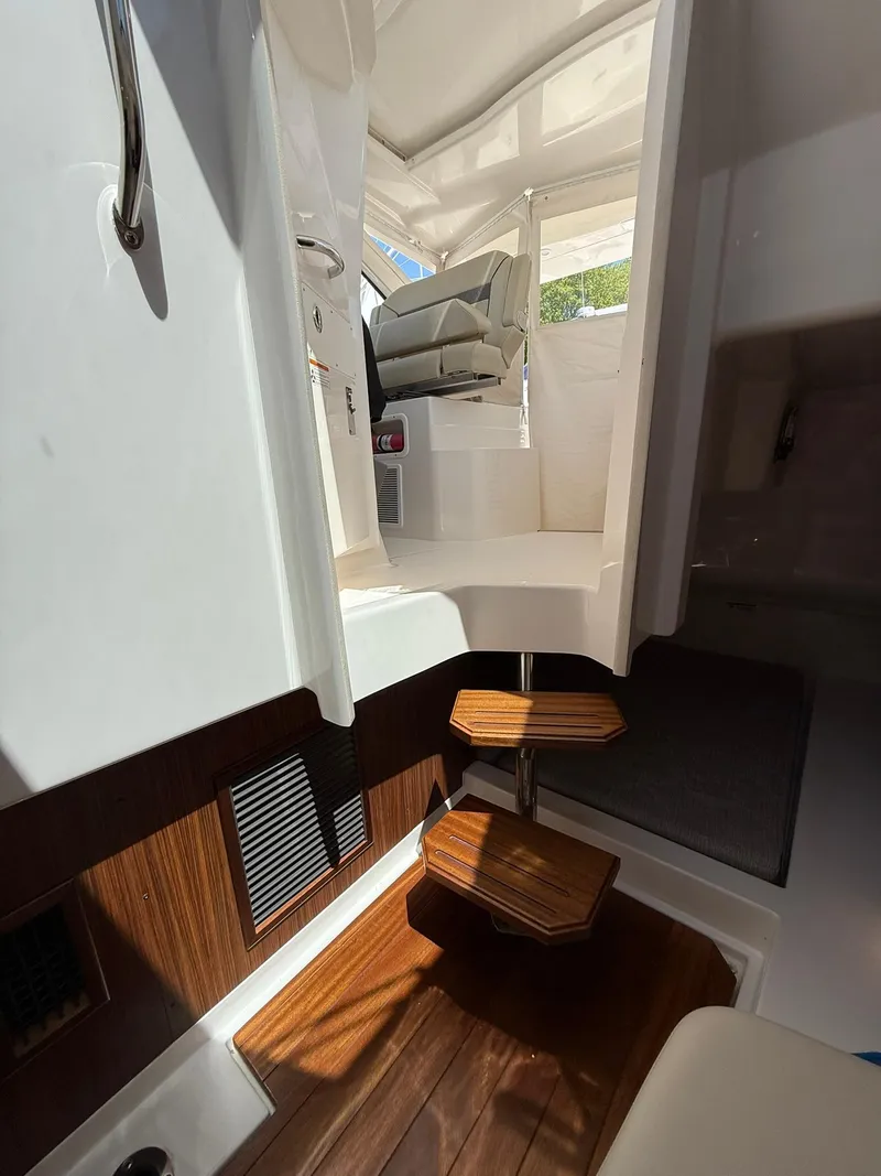 Slide: The Image of 2018 Pursuit DC 365 Dual Console interior with wooden steps and seating area. - 27