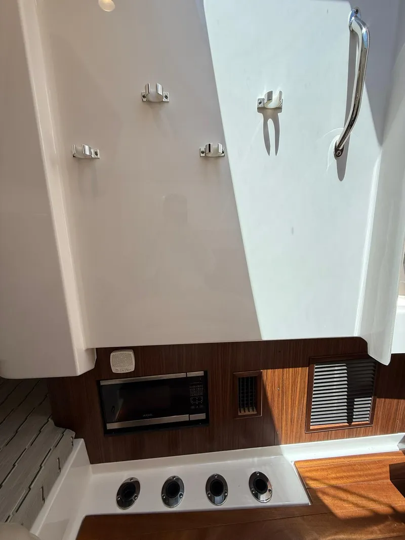 Slide: The Image of 2018 Pursuit DC 365 Dual Console interior with wood accents and modern fixtures. - 28