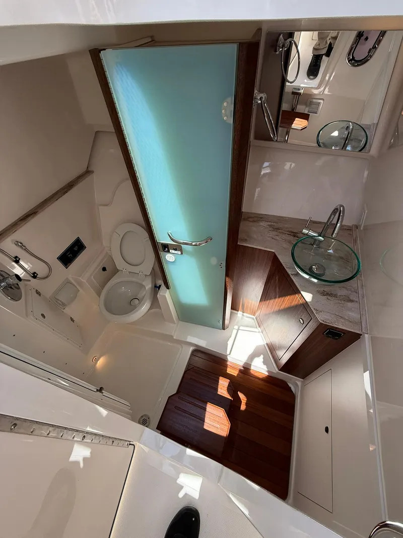 Slide: The Image of 2018 Pursuit DC 365 Dual Console boat interior with modern bathroom amenities. - 29