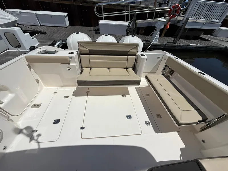 Slide: The Image of 2018 Pursuit DC 365 Dual Console boat interior with beige seating and spacious deck. - 3