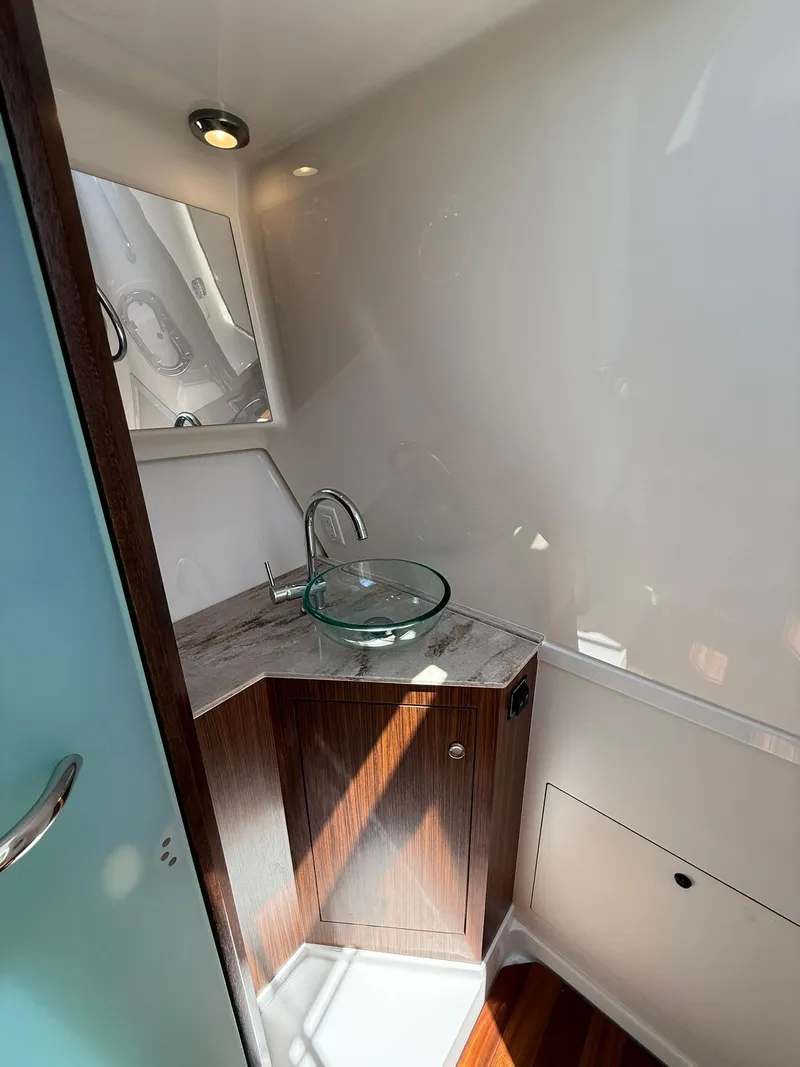 Slide: The Image of 2018 Pursuit DC 365 Dual Console bathroom with modern sink and wooden cabinetry. - 30