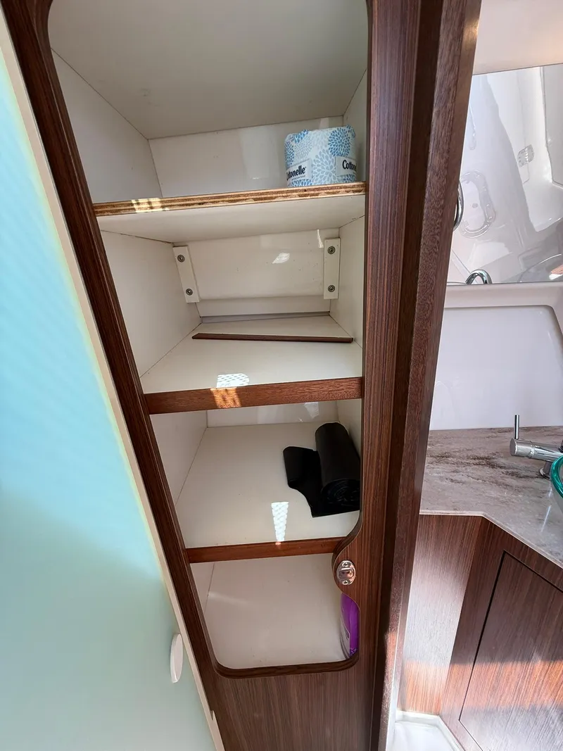 Slide: The Image of 2018 Pursuit DC 365 Dual Console interior cabinet with shelves and a small sink nearby. - 31