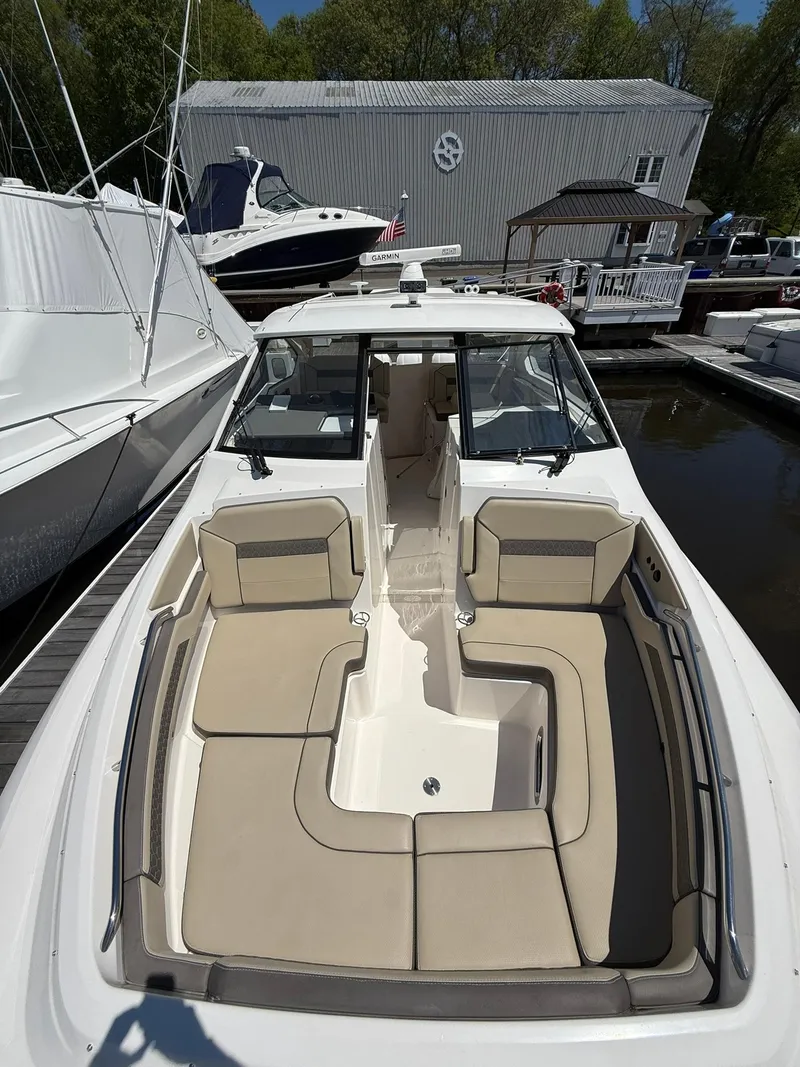 Slide: The Image of 2018 Pursuit DC 365 Dual Console boat with spacious seating at a marina. - 34
