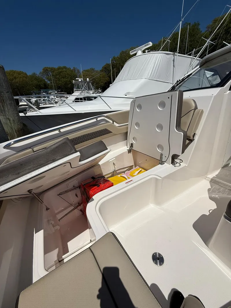 Slide: The Image of 2018 Pursuit DC 365 Dual Console boat interior with storage compartments and seating. - 35