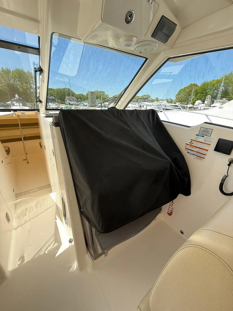 Slide: The Image of 2018 Pursuit DC 365 Dual Console interior with covered dashboard and clear windows. - 39