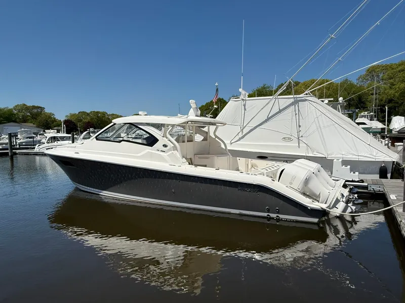 Slide: The Image of 2018 Pursuit DC 365 Dual Console boat docked in marina under clear blue sky. - 42