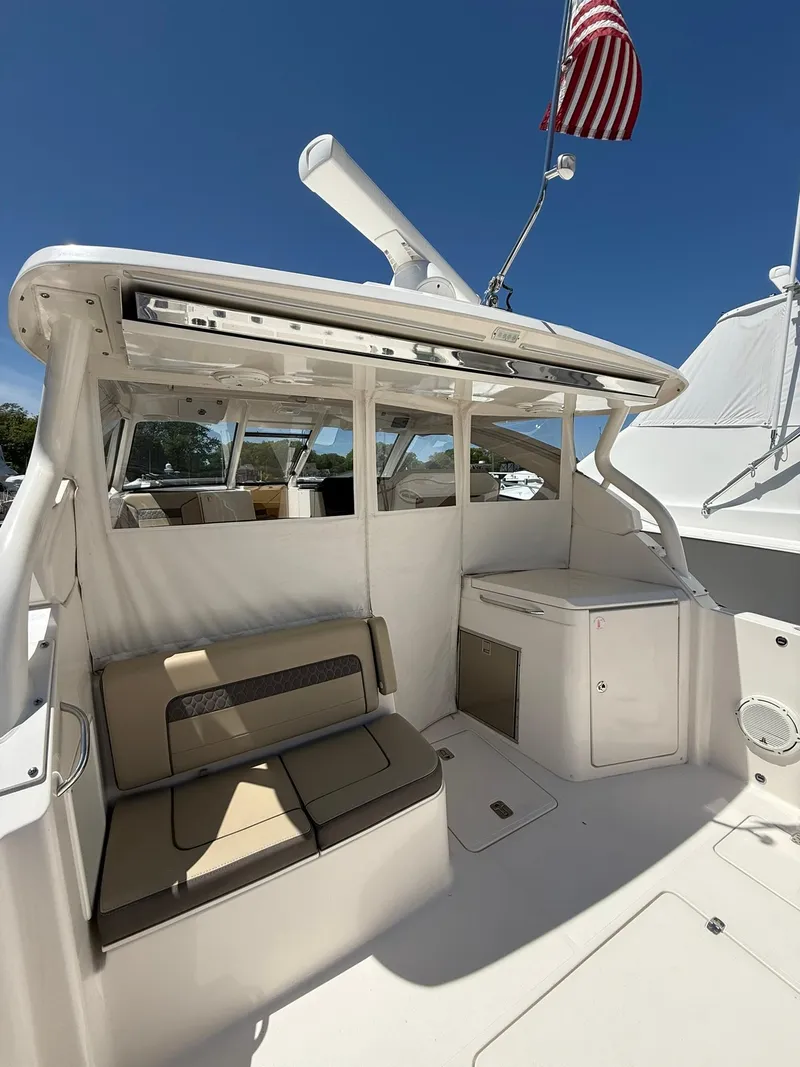 Slide: The Image of 2018 Pursuit DC 365 Dual Console boat with seating and American flag. - 5