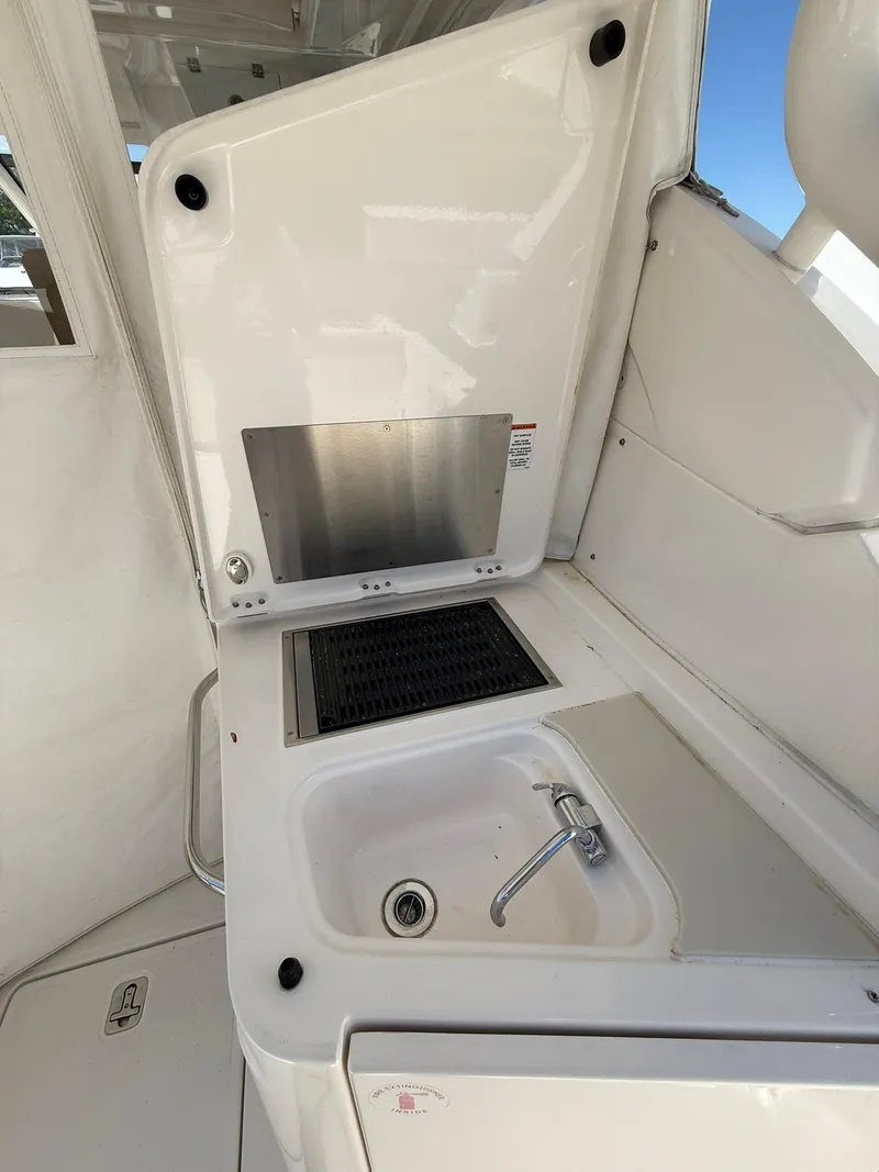 Slide: The Image of 2018 Pursuit DC 365 Dual Console boat kitchenette with sink and grill. - 7