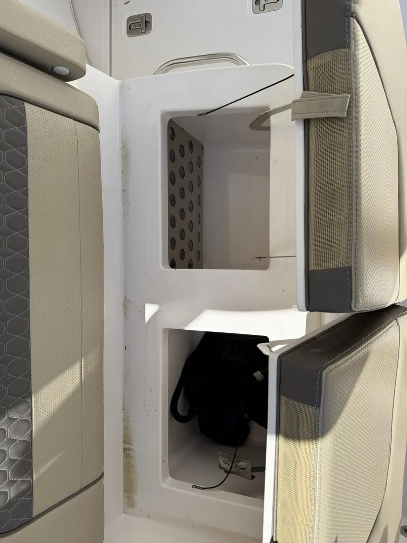 Slide: The Image of 2018 Pursuit DC 365 Dual Console interior storage compartments with cushioned seating. - 9