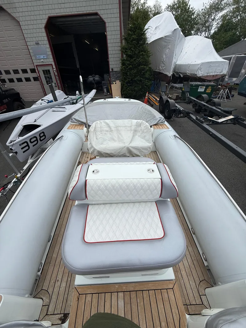 Slide: The Image of 2015 Castoldi 21 Diesel Jet Tender with cushioned seating and wooden deck in a marina setting. - 19