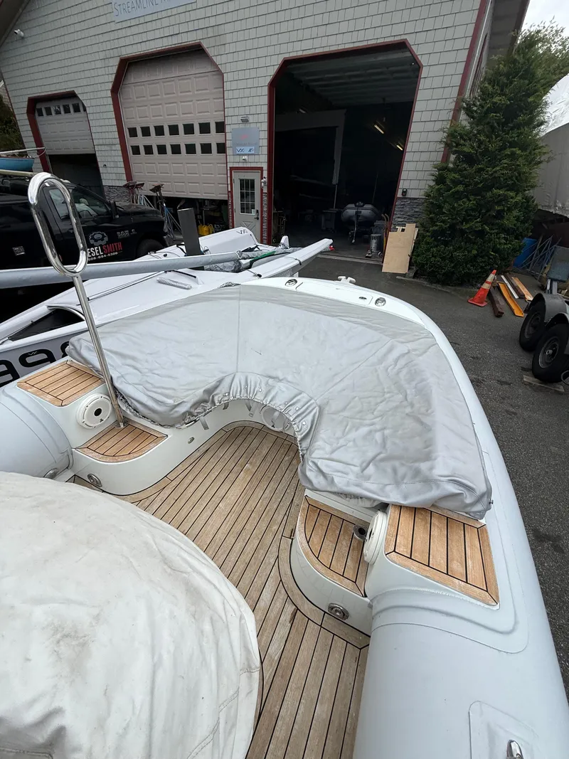 Slide: The Image of 2015 Castoldi 21 Diesel Jet Tender with covered seating, docked near a garage. - 21