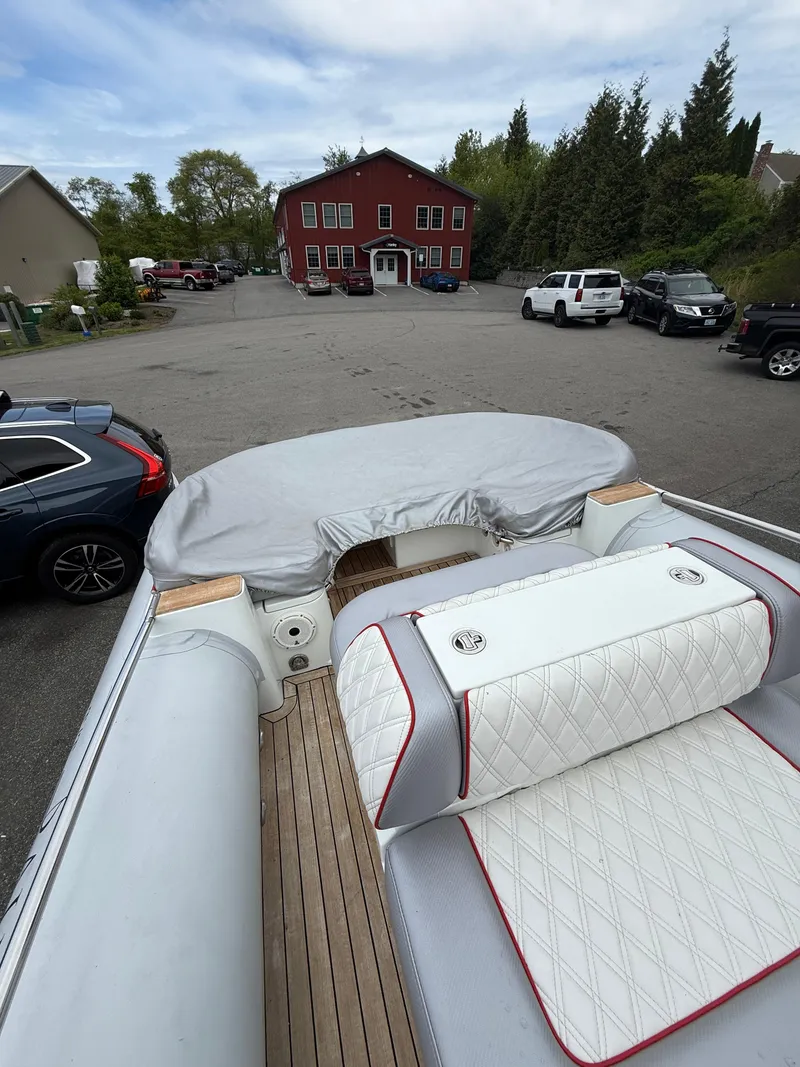 Slide: The Image of 2015 Castoldi 21 Diesel Jet Tender with white seating, parked in a lot near a red building. - 22