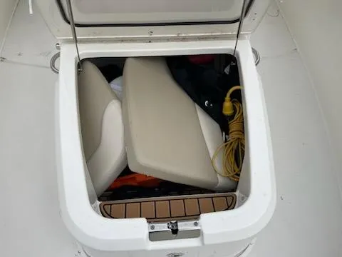 Slide: The Image of Storage compartment on a 2022 Boston Whaler 280 Outrage boat, containing seats and a yellow cord. - 16