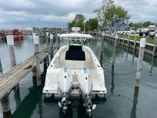 Slide: The Image of 2022 Boston Whaler 280 Outrage docked in a marina with twin engines. - 2