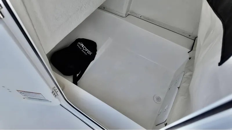 Slide: The Image of 2025 Sea Fox 248 Commander interior storage compartment with a black bag. - 10