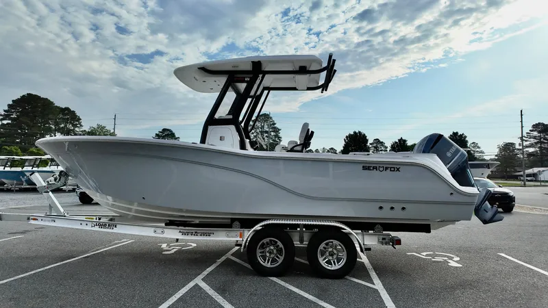 Slide: The Image of 2025 Sea Fox 248 Commander boat on trailer, parked in lot under cloudy sky. - 5