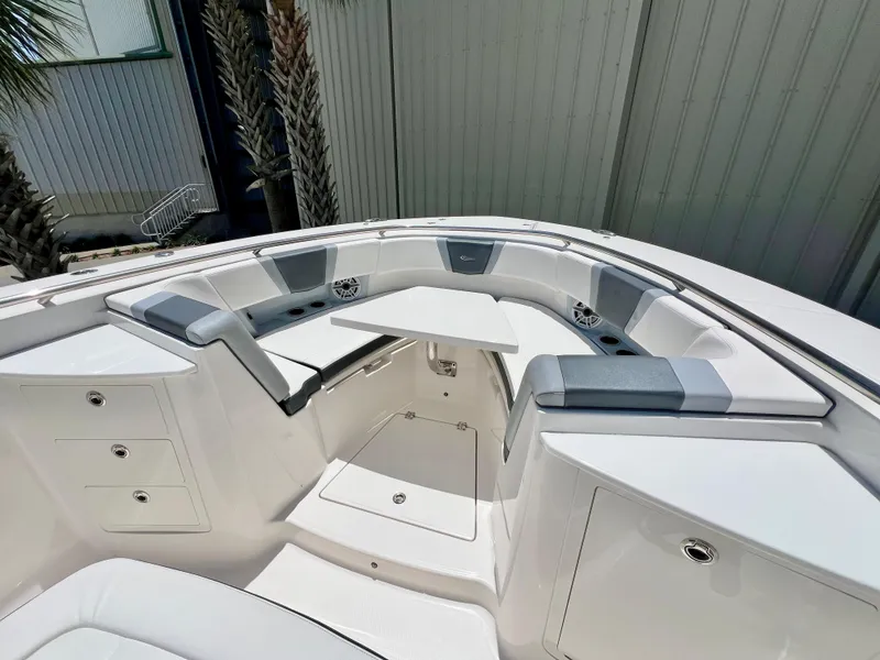 Slide: The Image of 2021 Robalo R360 Center Console boat interior with cushioned seating and storage compartments. - 22
