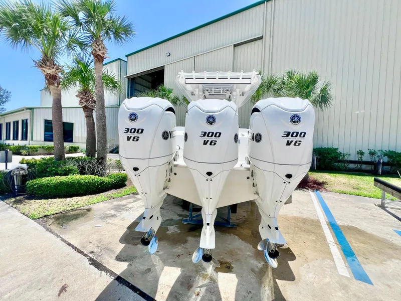 Slide: The Image of 2021 Robalo R360 Center Console with triple 300 VG engines, parked outdoors. - 3