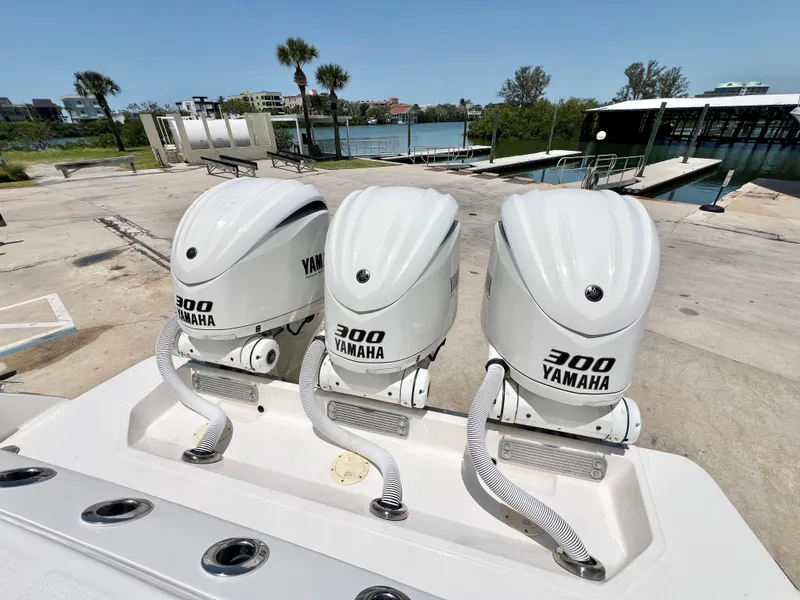 Slide: The Image of 2021 Robalo R360 Center Console with triple Yamaha 300 engines at a marina. - 7