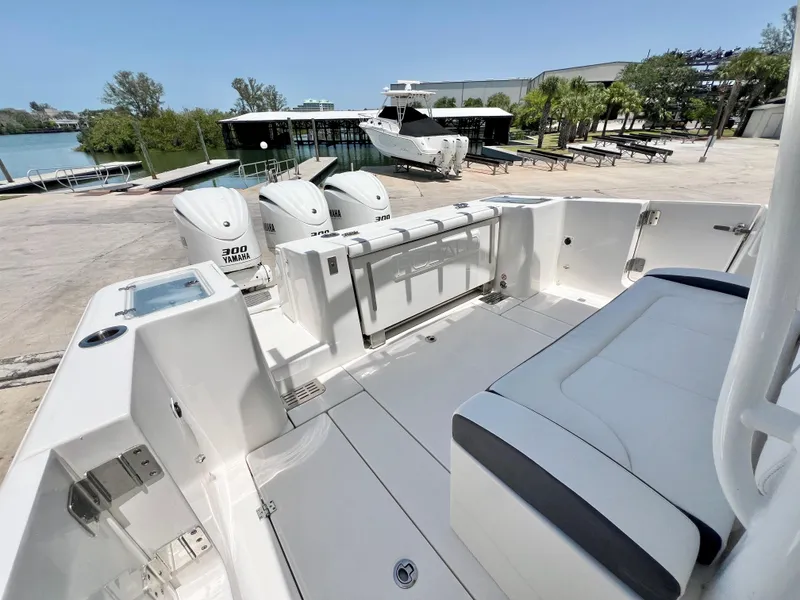 Slide: The Image of 2021 Robalo R360 Center Console boat with triple engines, docked near a waterfront. - 9
