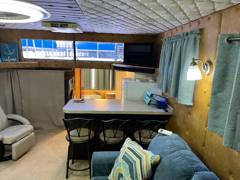 Slide: The Image of Cozy 1987 Sumerset Custom houseboat interior with seating, counter, and nautical decor. - 11