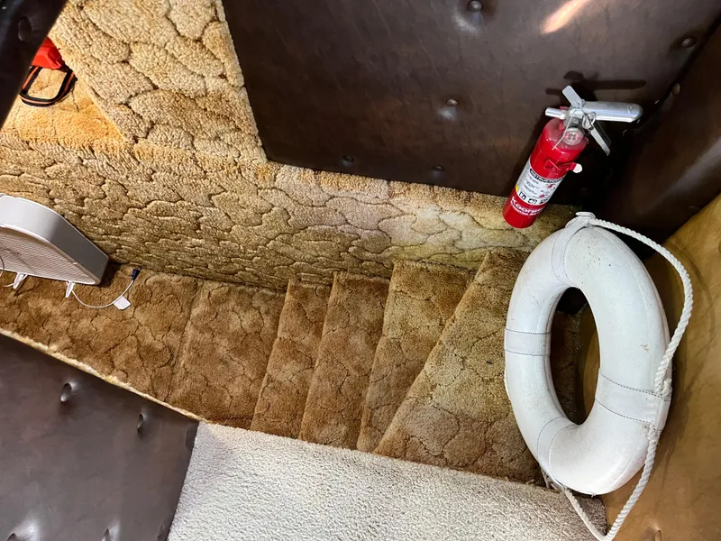 Slide: The Image of 1987 Sumerset Custom boat interior with carpeted stairs, fire extinguisher, and life preserver. - 18