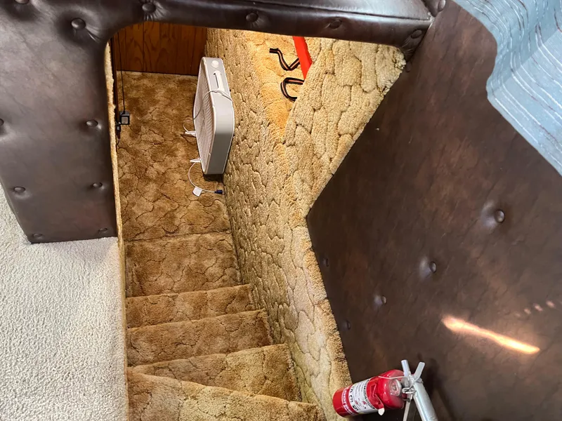 Slide: The Image of Staircase with beige carpet, fan, and fire extinguisher in 1987 Sumerset Custom interior. - 19