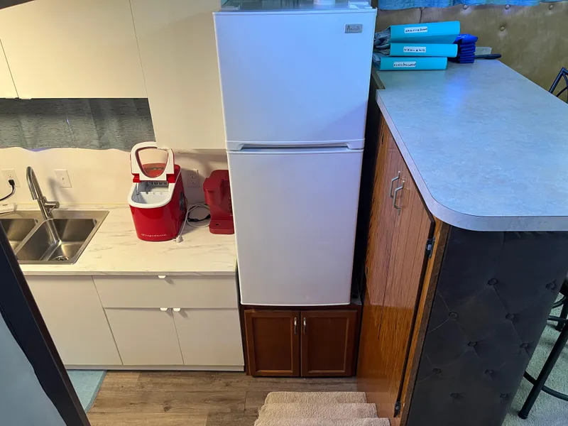 Slide: The Image of Compact kitchen area in a 1987 Sumerset Custom houseboat with fridge, sink, and countertop appliances. - 28