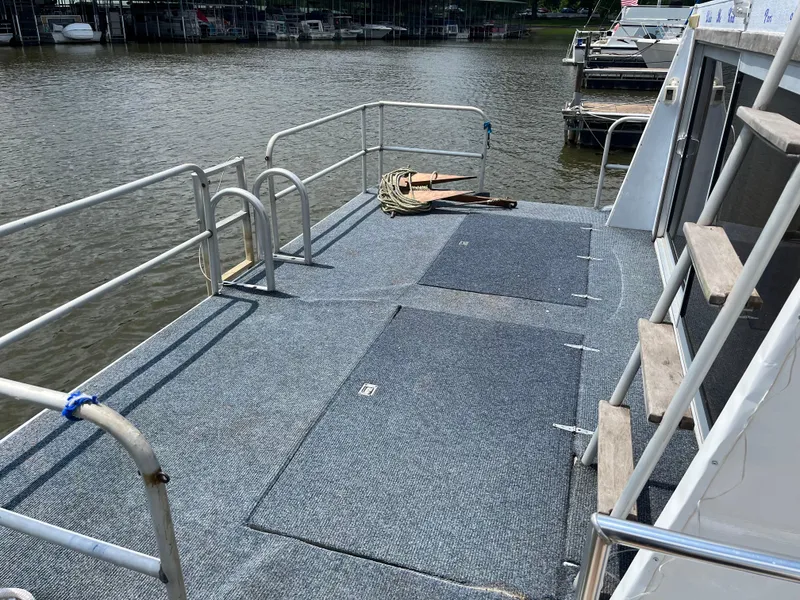 Slide: The Image of 1987 Sumerset Custom houseboat deck with railing, carpeted flooring, and dockside view. - 3