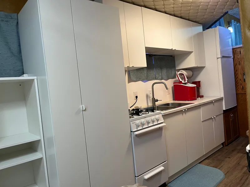 Slide: The Image of Compact kitchen in a 1987 Sumerset Custom houseboat with white cabinets and appliances. - 30