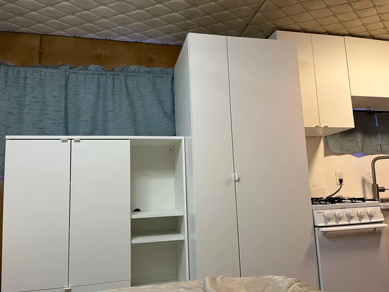 Slide: The Image of Compact kitchen area in a 1987 Sumerset Custom houseboat with white cabinets and stove. - 31