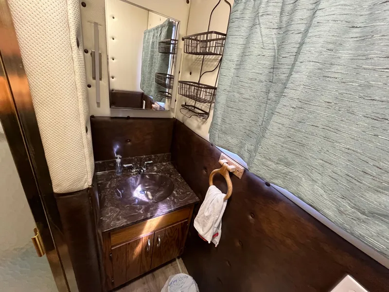 Slide: The Image of 1987 Sumerset Custom bathroom with marble sink, mirror, and storage shelves. - 33