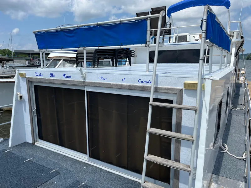 Slide: The Image of 1987 Sumerset Custom houseboat with blue canopy and ladder on deck. - 4