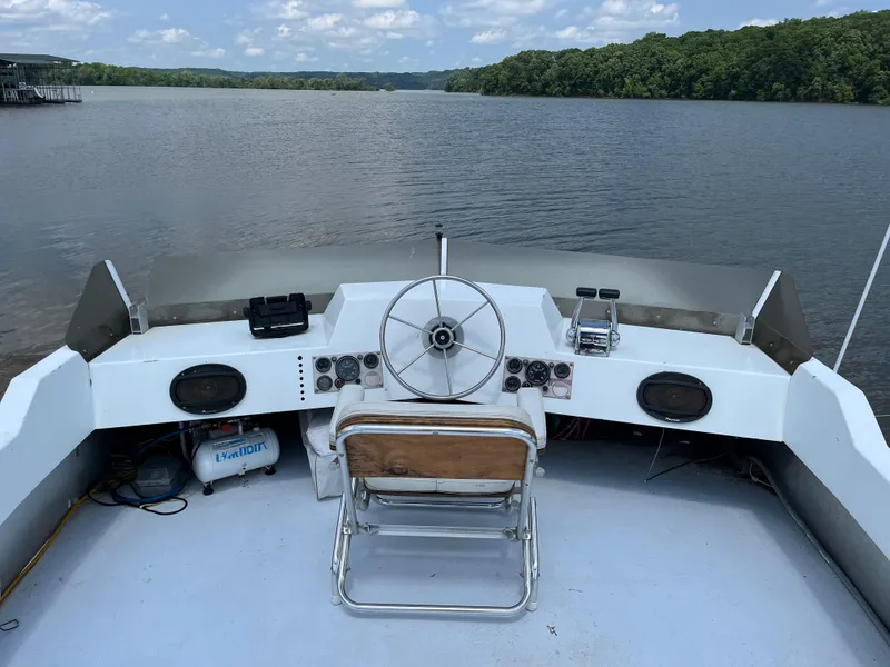 Slide: The Image of 1987 Sumerset Custom boat helm with steering wheel, controls, and lake view. - 8
