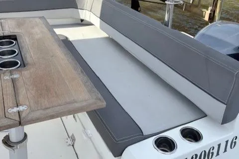 Slide: The Image of 2020 Jeanneau Leader 9.0 CC boat with gray seating and wooden table. - 16