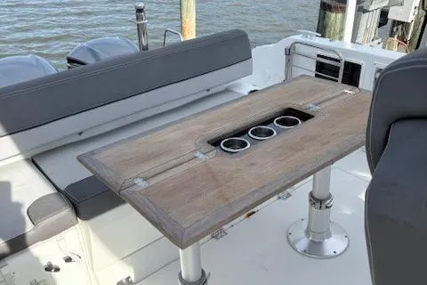 Slide: The Image of 2020 Jeanneau Leader 9.0 CC boat interior with wooden table and cup holders. - 17